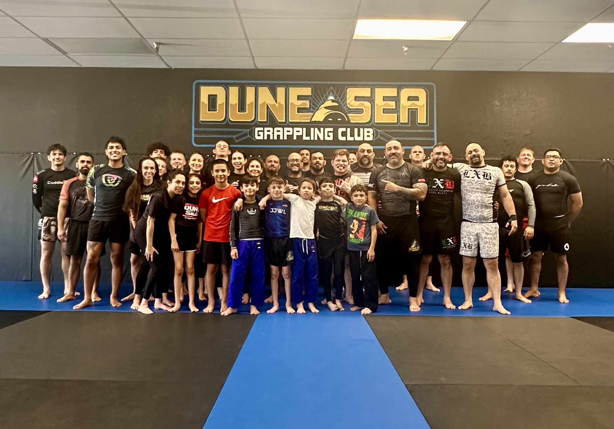 Dune Sea team lined up together on the mats beneath the club sign